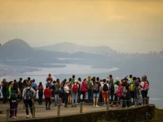 Turistas na estrada: Caminhos do Mar cercada pela exuberante Mata Atlântica.