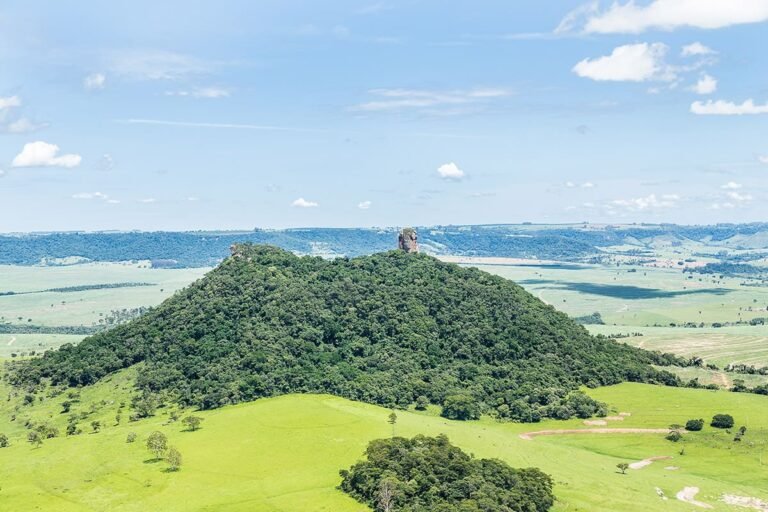 Vista panorâmica da formação rochosa Pedra de Torrinha, uma das principais atrações turísticas da cidade de Torrinha, com paisagens verdejantes e céu azul ao fundo, ideal para atividades ao ar livre e esportes de aventura.